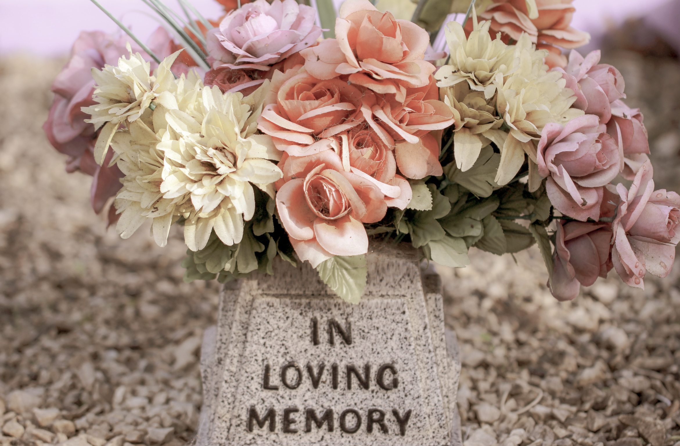 Flowers surround tombstone that reads "In loving memory" to represent probate