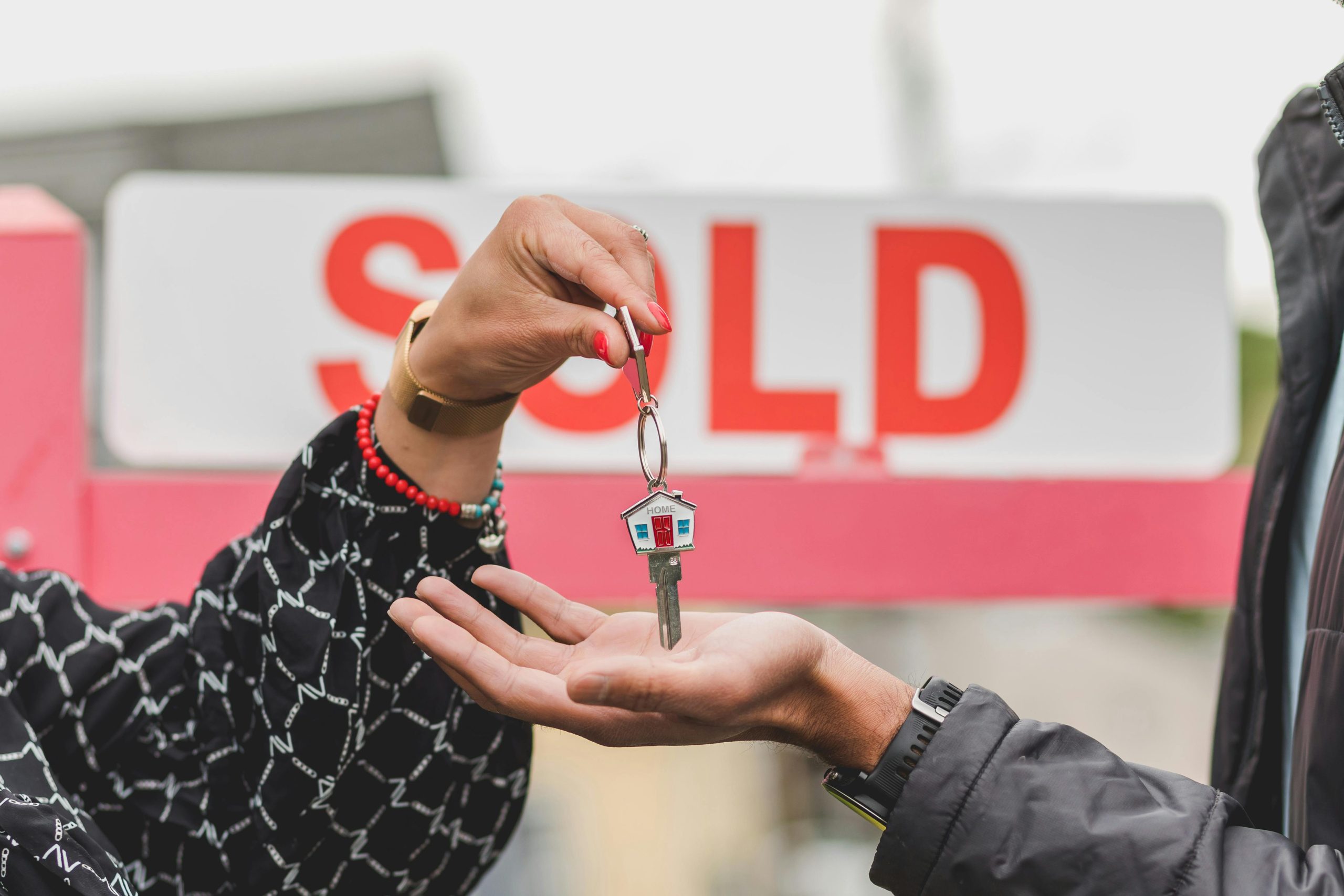 One person hands keys to auction winner.